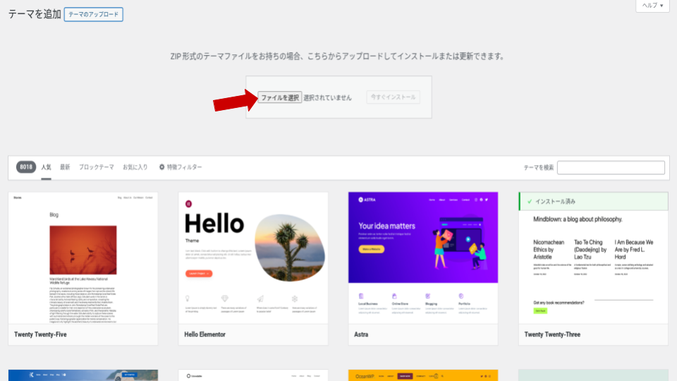 WordPressのテーマアップロード画面。「ファイルを選択」ボタンを赤い矢印で示している状態